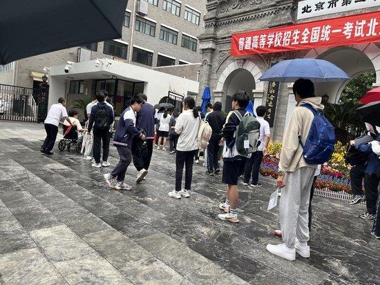 高考雨中开考 家长们撑伞架起一条干爽送考路插图1